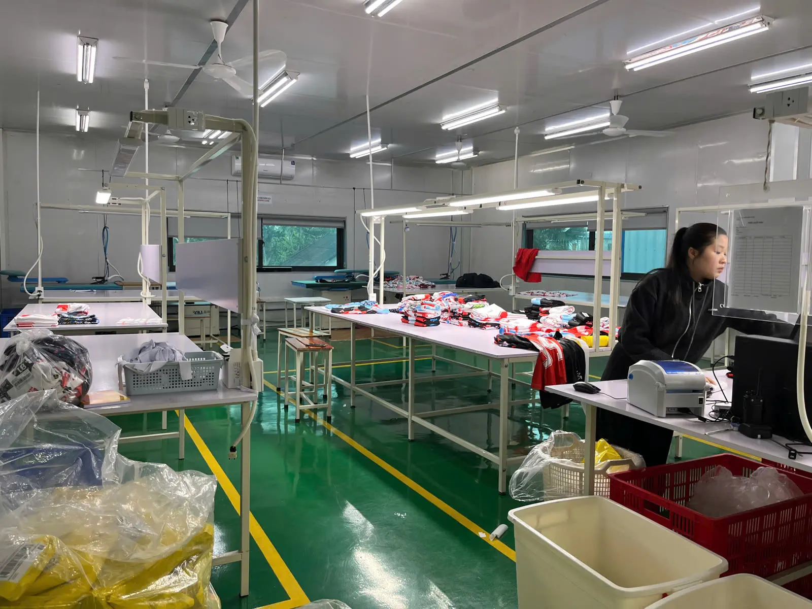 Trang phục đã in được sắp xếp tại bàn hoàn thiện