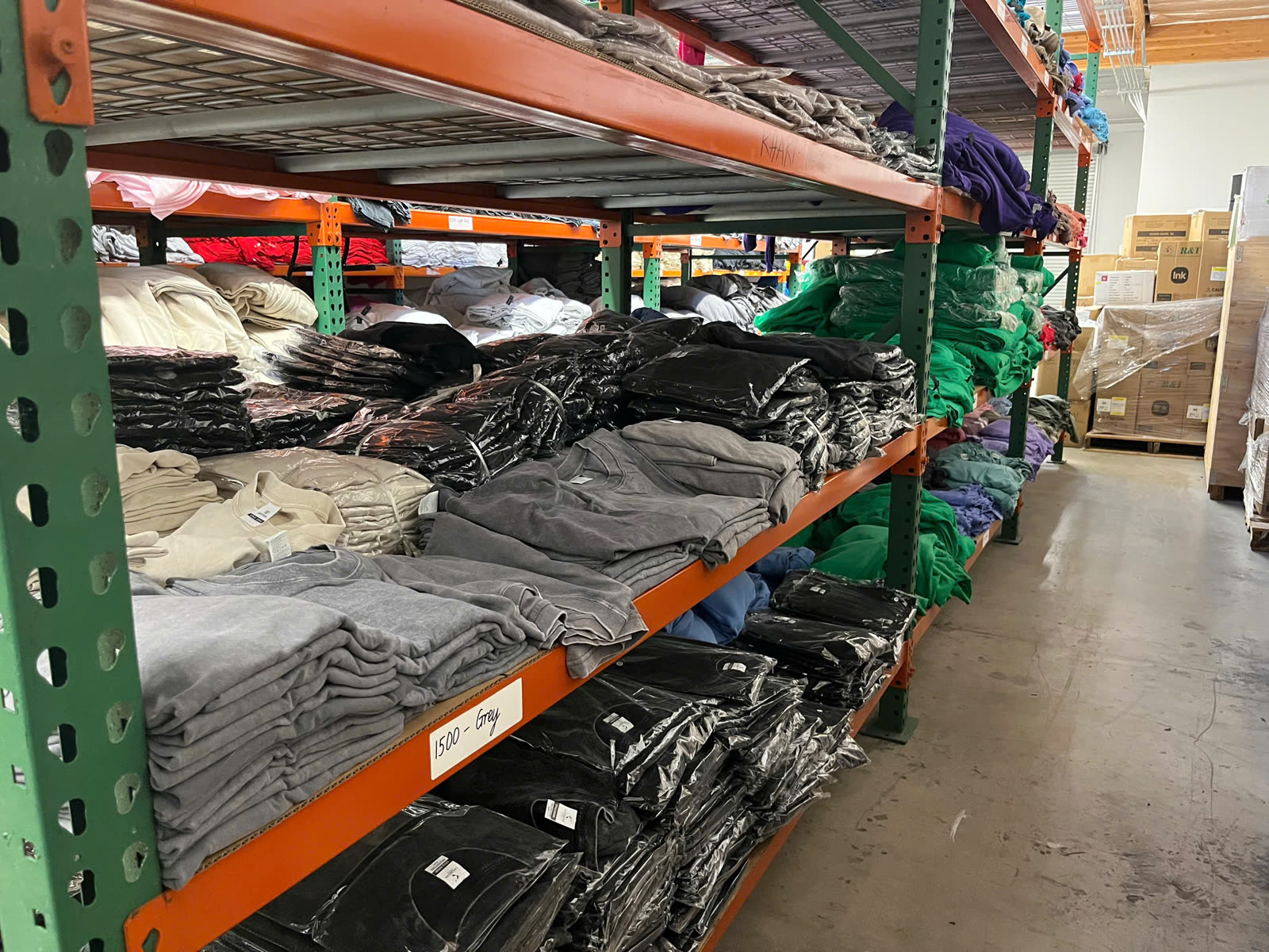 Warehouse racking of folded blank apparel sorted by colour